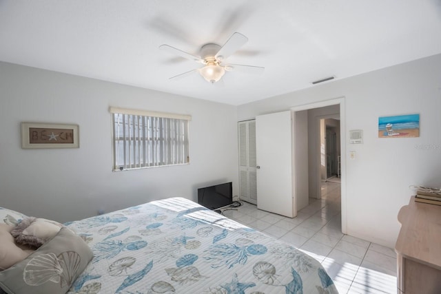 bedroom featuring ceiling fan, a closet, and light tile patterned flooring