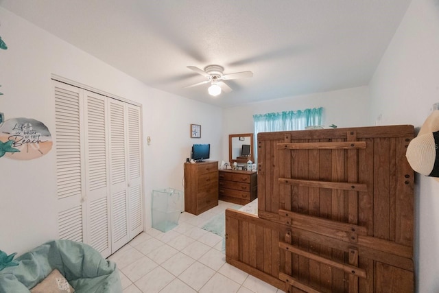 bedroom with ceiling fan, a closet, and light tile patterned flooring