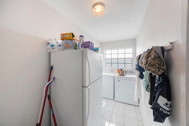 laundry room with separate washer and dryer, light tile patterned floors, and a textured ceiling