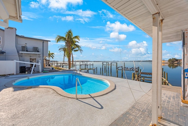 view of swimming pool with a boat dock, a patio area, and a water view