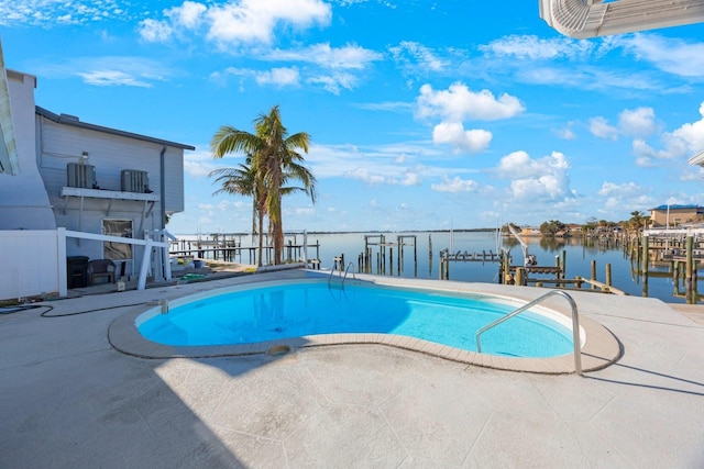 view of pool featuring cooling unit, a patio area, a water view, and a boat dock