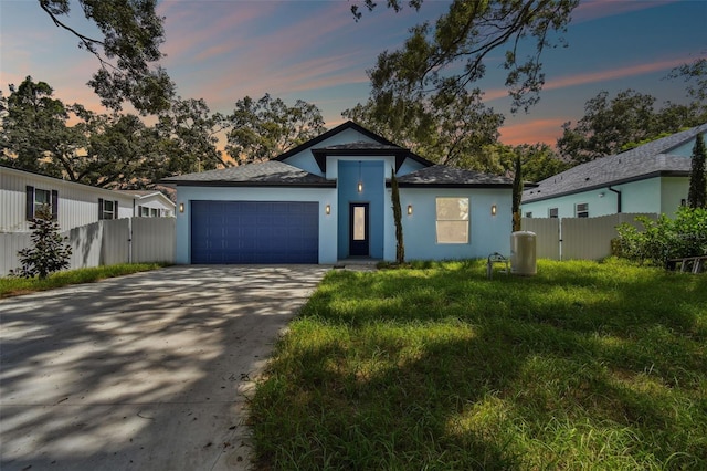 view of front of home with a garage and a lawn