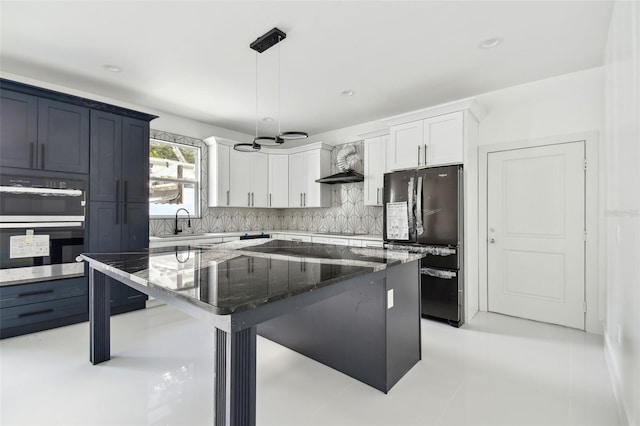 kitchen featuring stone counters, a kitchen island, pendant lighting, white cabinets, and black appliances