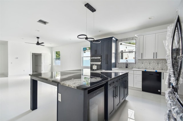 kitchen featuring white cabinetry, dishwasher, a kitchen island, and ceiling fan