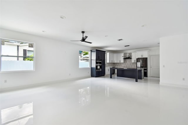 unfurnished living room with ceiling fan and a healthy amount of sunlight