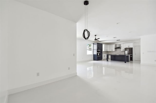 unfurnished living room featuring ceiling fan and concrete flooring