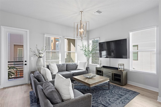 living room with a chandelier and light wood-type flooring