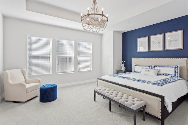 bedroom featuring carpet, a tray ceiling, and a notable chandelier