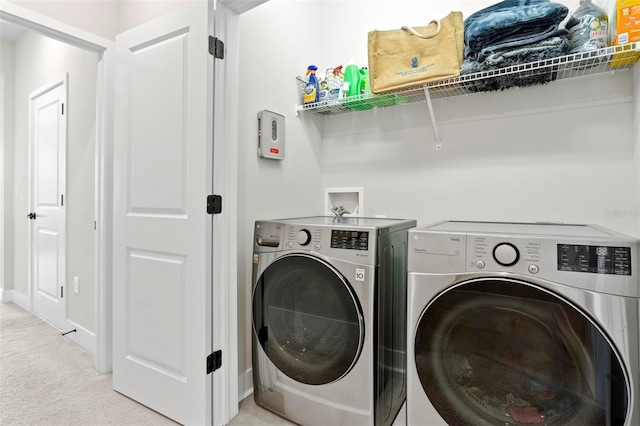 washroom with light carpet and washer and dryer