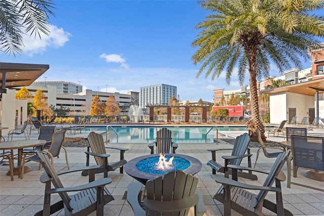 view of swimming pool featuring a patio and a fire pit