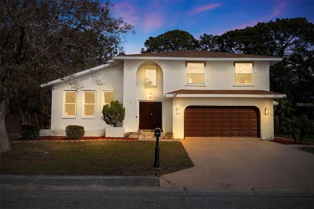 front of property with a yard and a garage