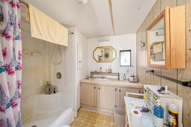 bathroom with walk in shower, wood walls, and vanity