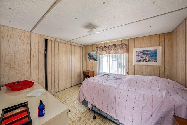 bedroom with wood walls and a textured ceiling