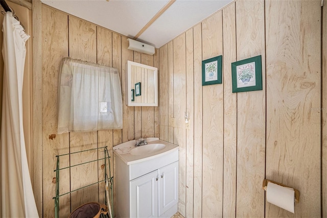 bathroom featuring vanity and wooden walls