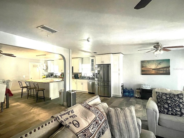 living room featuring a textured ceiling, dark hardwood / wood-style floors, and sink