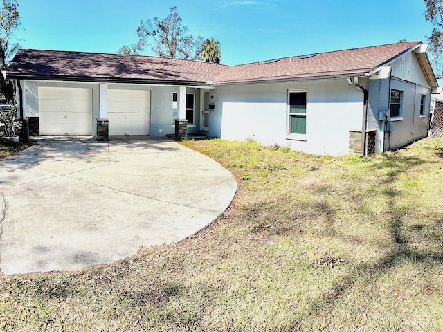 single story home with a garage and a front lawn