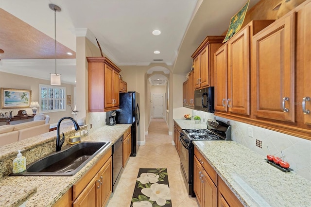 kitchen featuring light stone countertops, sink, hanging light fixtures, backsplash, and black appliances