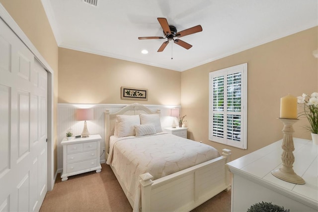 bedroom featuring carpet flooring, ceiling fan, a closet, and crown molding