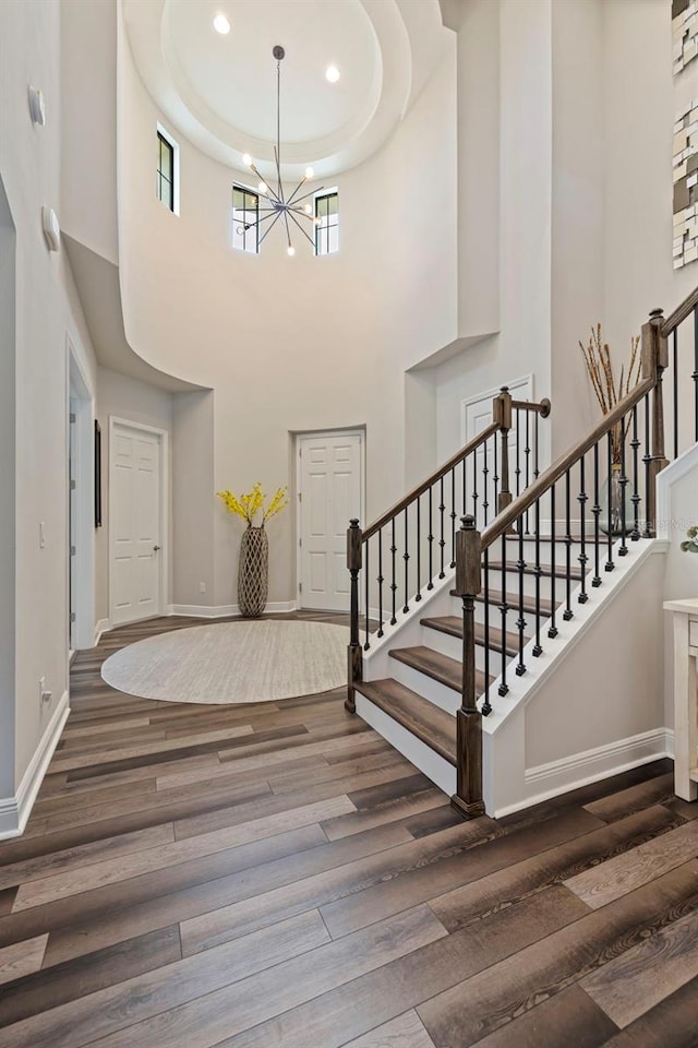 foyer entrance featuring a high ceiling, dark wood-type flooring, and a notable chandelier