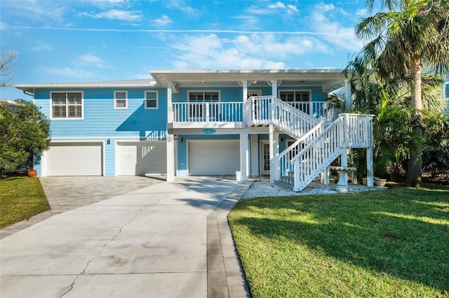 beach home featuring covered porch, a front lawn, and a garage