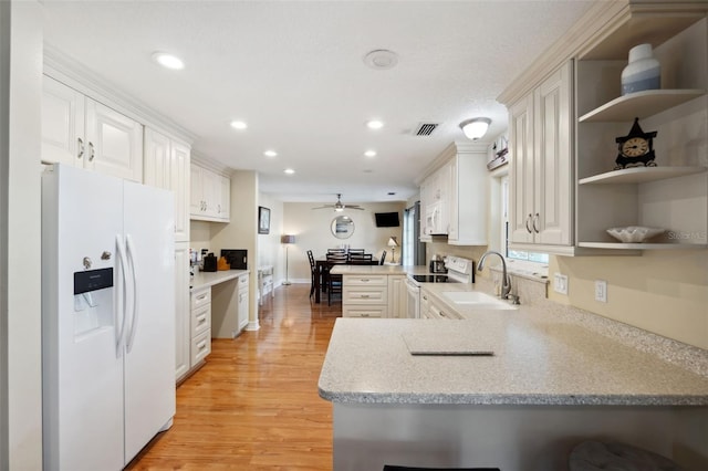 kitchen featuring white appliances, kitchen peninsula, light hardwood / wood-style floors, white cabinetry, and ceiling fan