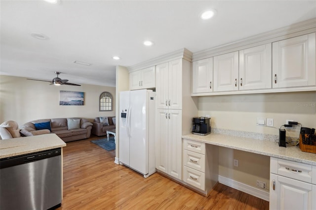 kitchen with white refrigerator with ice dispenser, dishwasher, built in desk, ceiling fan, and white cabinetry