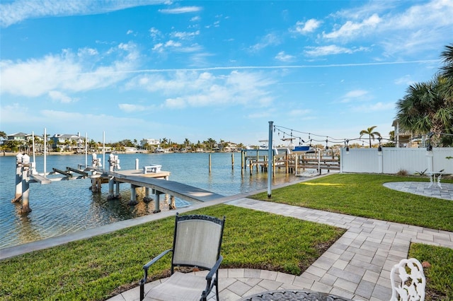 view of dock with a lawn and a water view