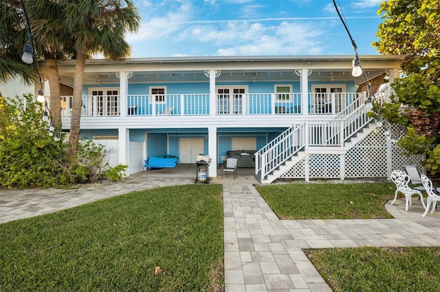 rear view of house featuring a porch, a yard, and a carport