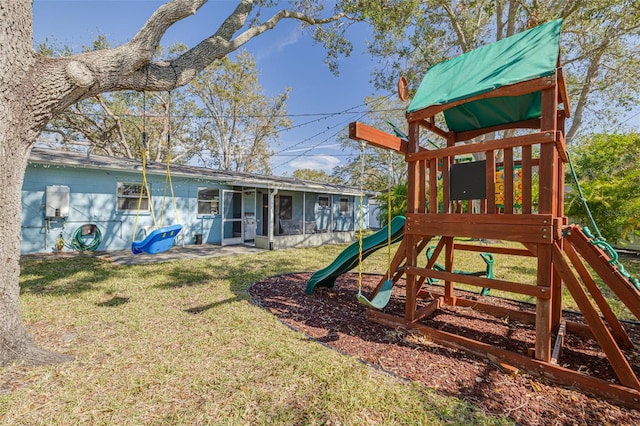 view of jungle gym with a sunroom and a yard