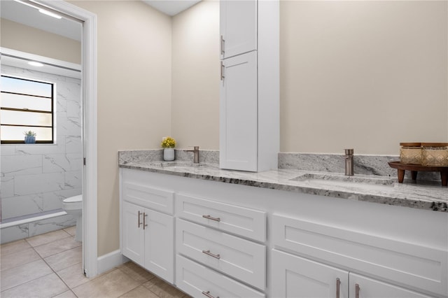 bathroom with toilet, tile patterned floors, and vanity