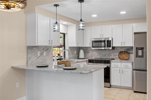 kitchen with appliances with stainless steel finishes, white cabinetry, kitchen peninsula, and sink