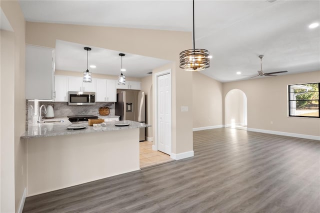 kitchen featuring appliances with stainless steel finishes, kitchen peninsula, ceiling fan, sink, and white cabinetry