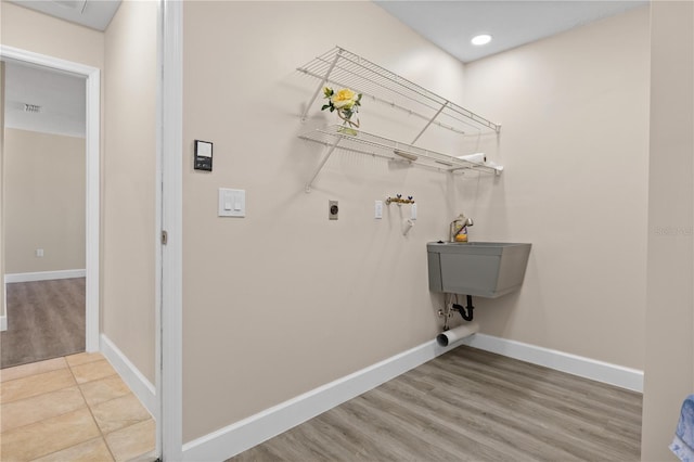 laundry room featuring electric dryer hookup and light wood-type flooring