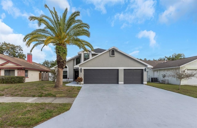 view of front of house featuring central AC unit, a front lawn, and a garage