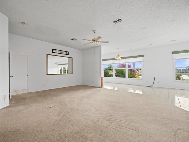 unfurnished room featuring a textured ceiling, ceiling fan, and light carpet