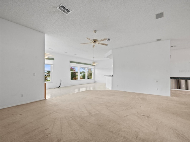 unfurnished living room featuring a textured ceiling, ceiling fan, and light colored carpet