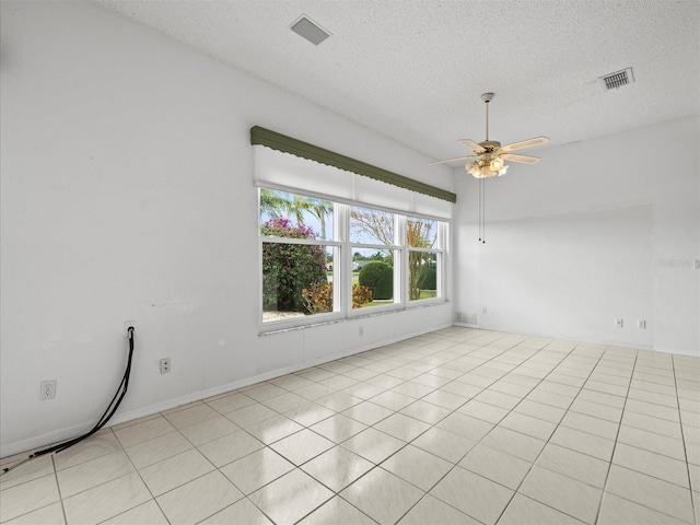 tiled empty room with a textured ceiling and ceiling fan