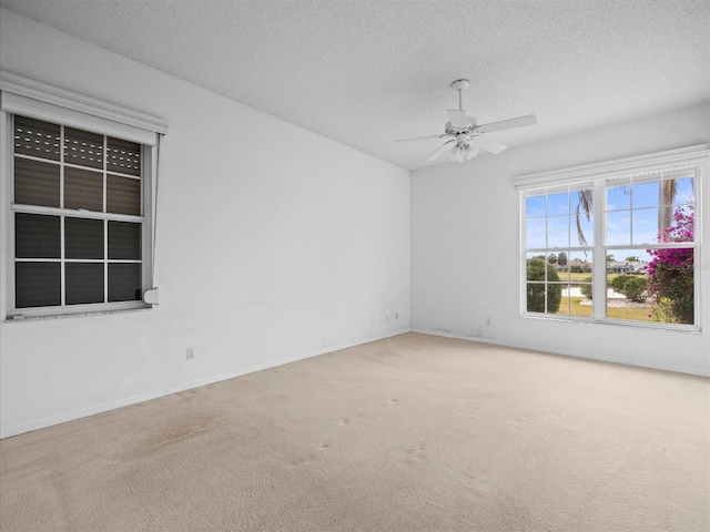 carpeted spare room with a textured ceiling and ceiling fan