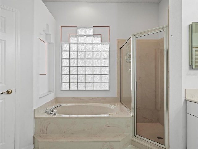 bathroom with vanity and shower with separate bathtub