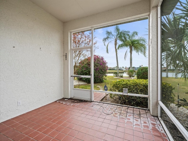 unfurnished sunroom featuring a water view