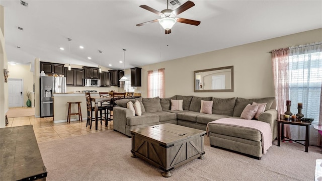 living room with ceiling fan, light tile patterned floors, and vaulted ceiling