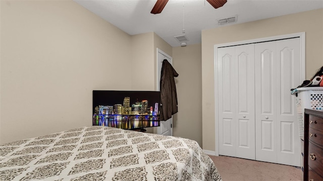 carpeted bedroom with ceiling fan and a closet