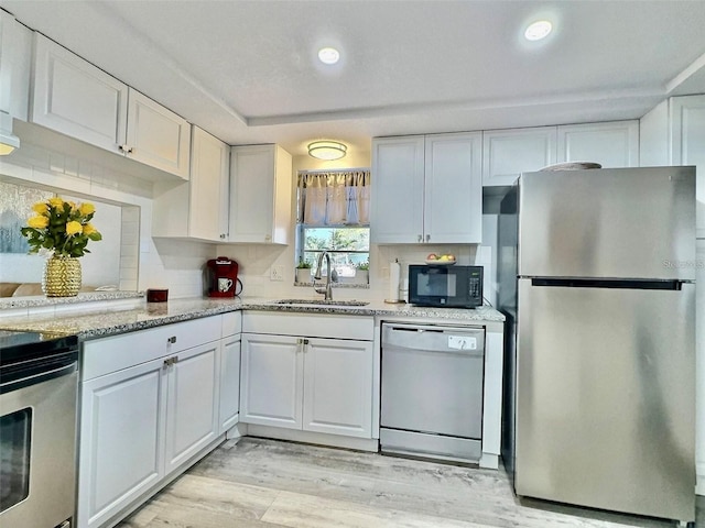 kitchen featuring tasteful backsplash, sink, white cabinets, and stainless steel appliances