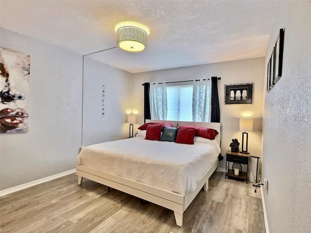 bedroom with wood-type flooring and a textured ceiling