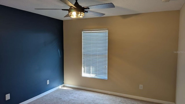 empty room with light carpet, a textured ceiling, and ceiling fan