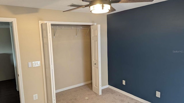 unfurnished bedroom featuring ceiling fan, light carpet, and a closet