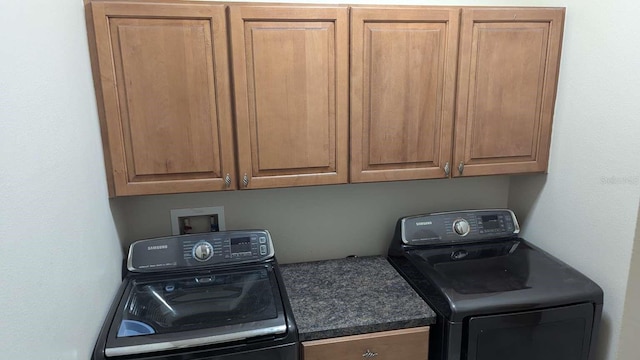 washroom featuring cabinets and washing machine and clothes dryer