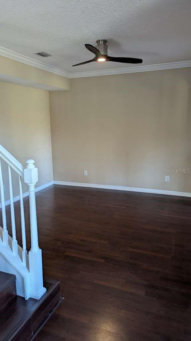 spare room with crown molding, ceiling fan, dark wood-type flooring, and a textured ceiling