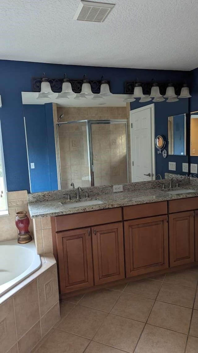 bathroom with tile patterned flooring, vanity, a textured ceiling, and independent shower and bath