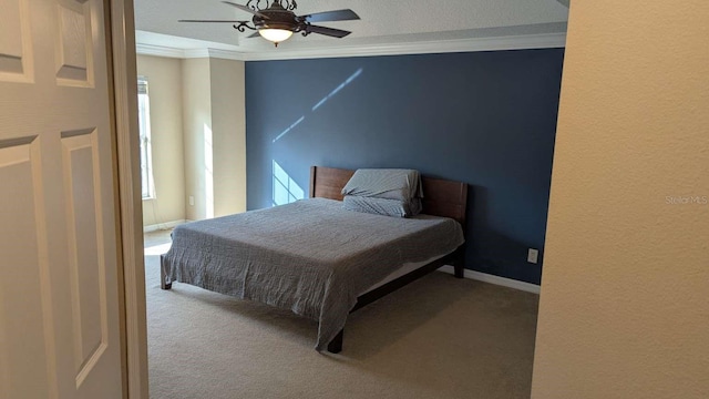 carpeted bedroom with a textured ceiling, ceiling fan, and crown molding